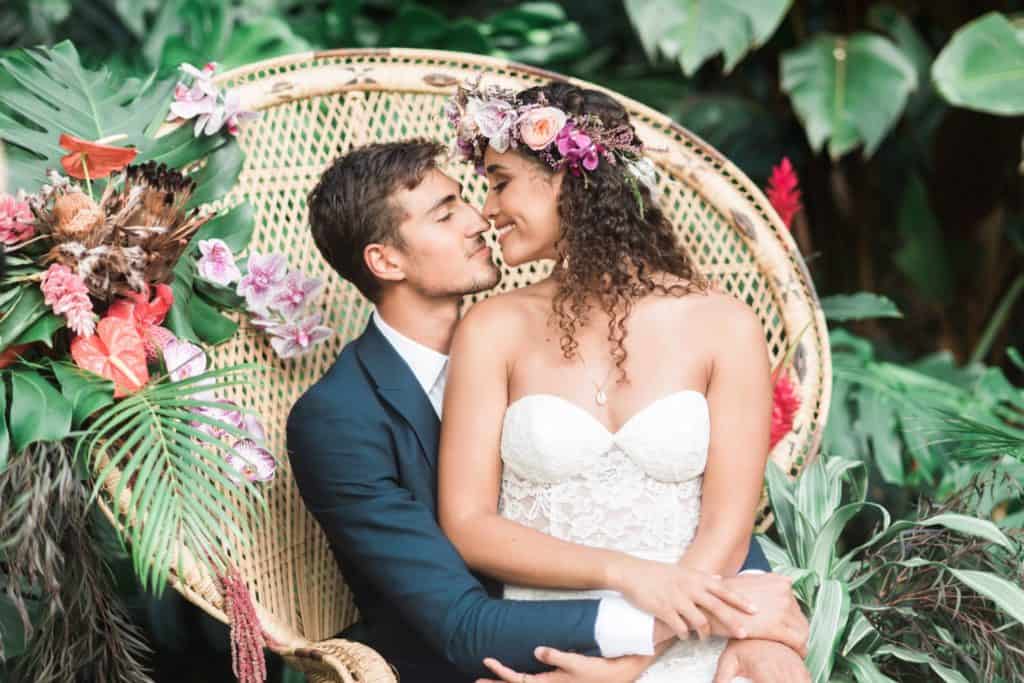 bride and groom on a peacock chair in hawaii