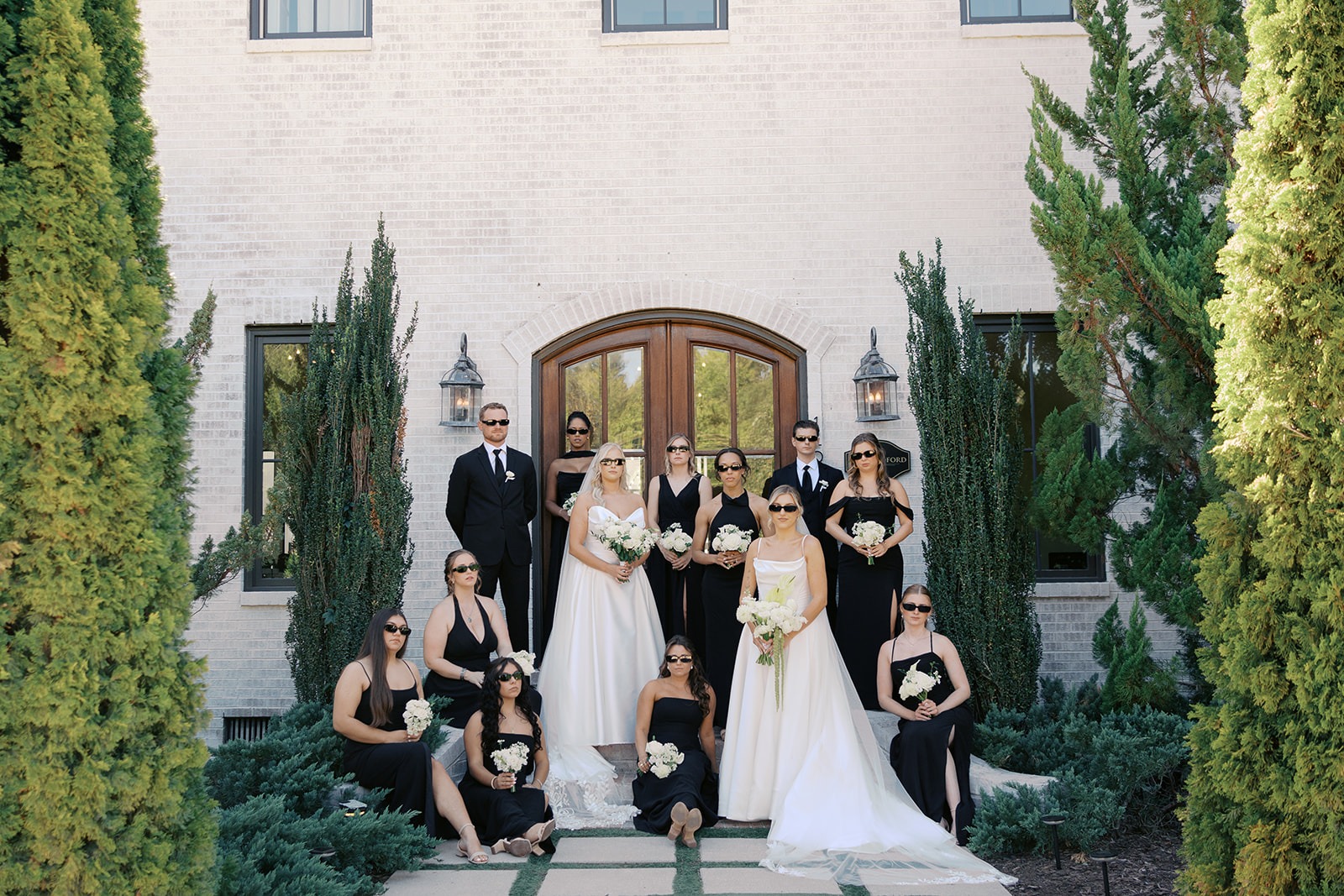 bridal party in black with sunglasses in front of the bradford main house doors
