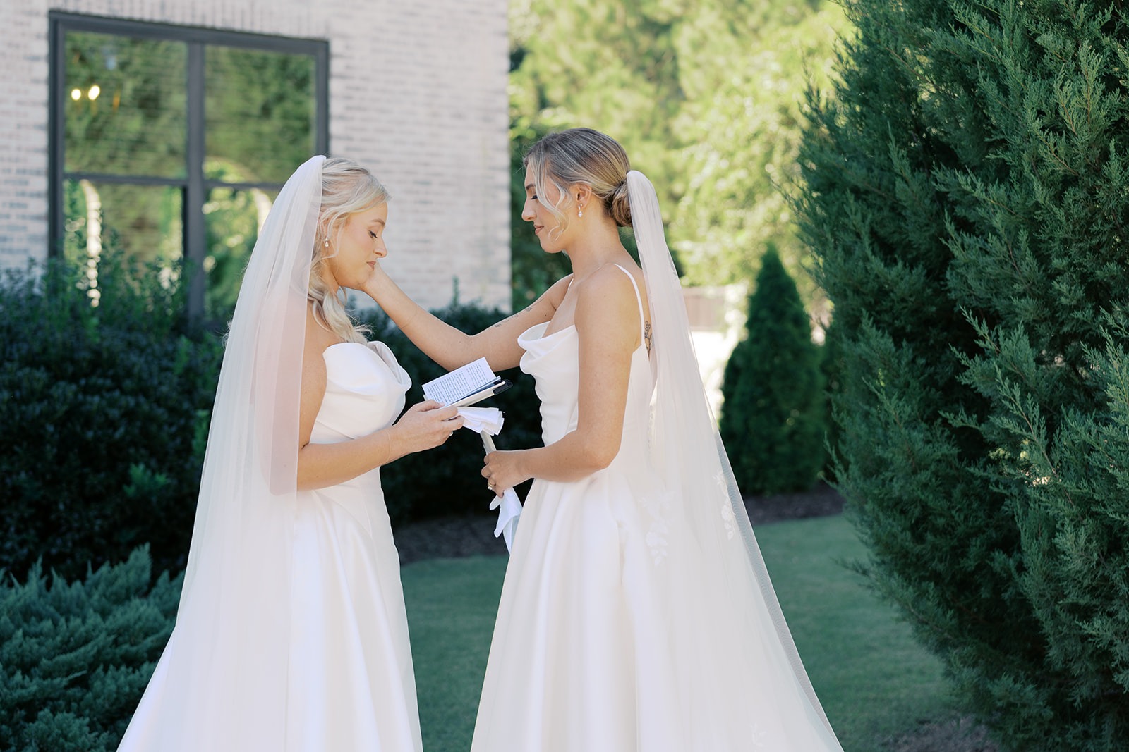 two brides exchanging private vows beside the bradford main house